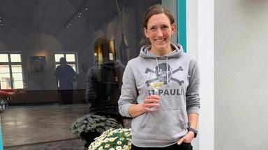 Eine Frau mit einem Glas Weißwein in der Hand