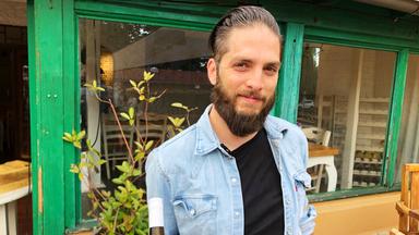 Ein junger Mann vor einem Restaurant.