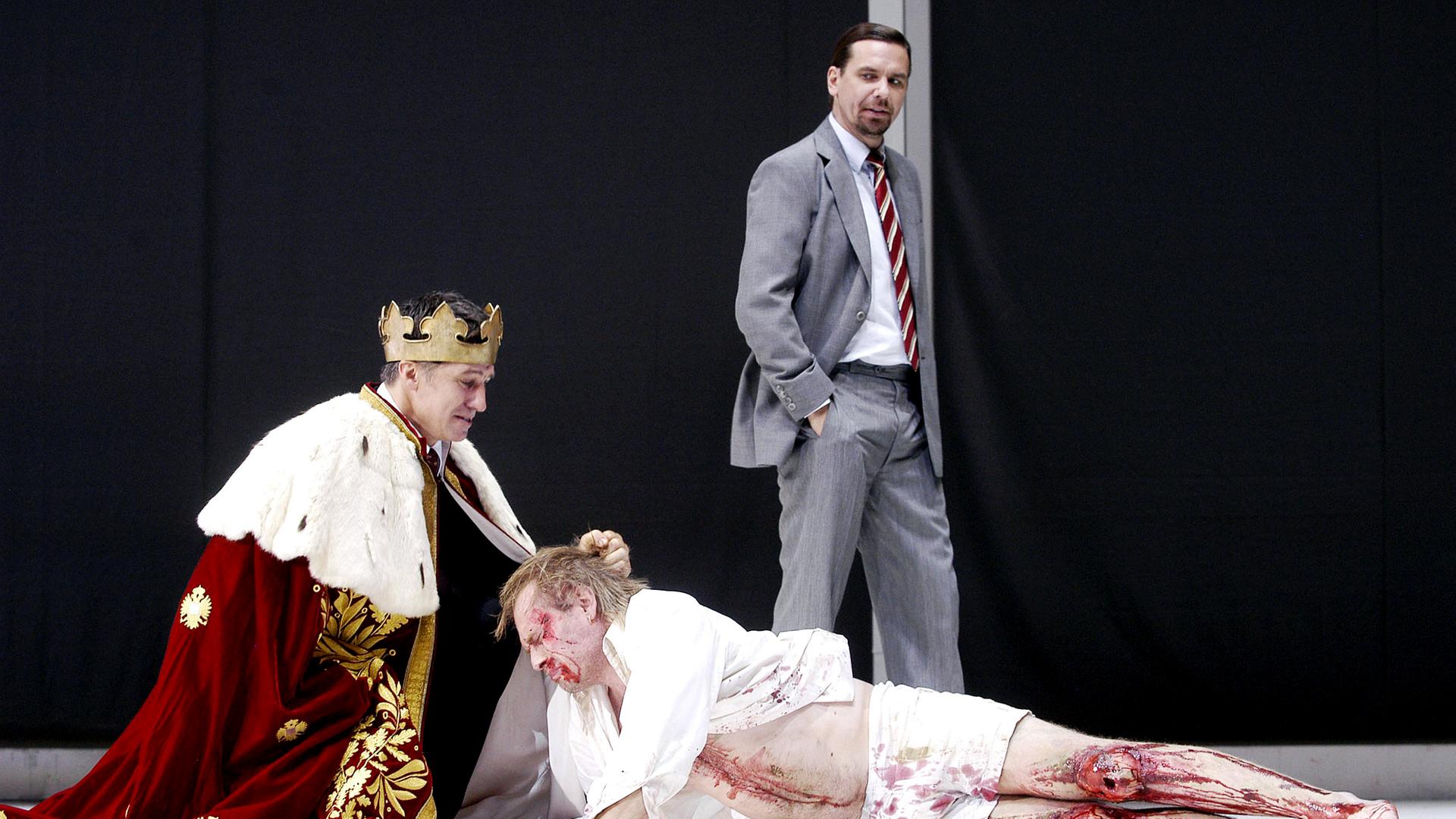 Bühnenszene: König beugt sich über Schwerverletzten