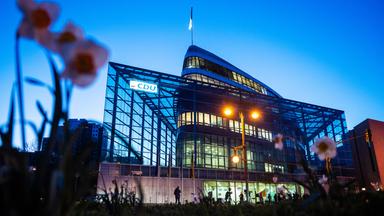 Die CDU-Zentrale Konrad Adenauer Haus - ein modernes Gebäude mit viel Glas, das an ein Schiff erinnert - im Abendlicht.