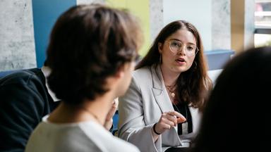 Shelly ist im Gespräch mit einer Gruppe junger Menschen.