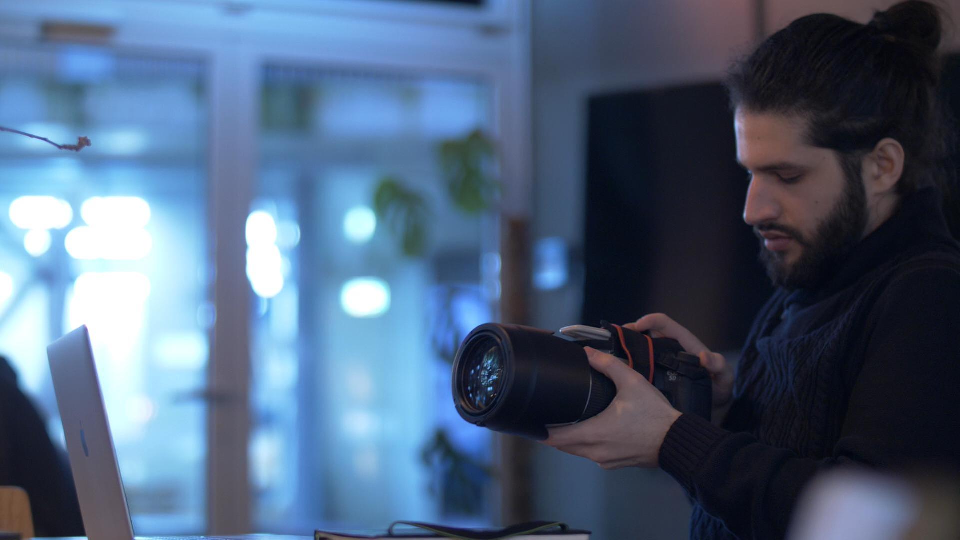 Kriegsfotografie - Fotograf hält seine Kamera in der Hand. Er hat sie immer dabei.