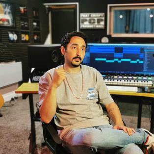 „Kültür für Deutschland“: Rapper Eko Fresh in seinem Studio in Köln. Er sitzt auf einem Sessel, hinter ihm ist ein Mischpult, ein Keyboard, eine Gitarre und eine Tonkabine zu sehen.