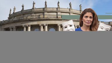 Katty Salié vor einem Theater mit zwei Masken in der Hand