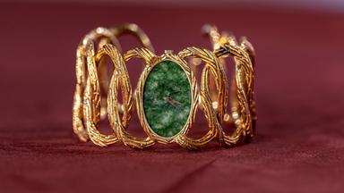 Uhr mit goldenem Schmuck-Armband und grünem Ziffernblatt