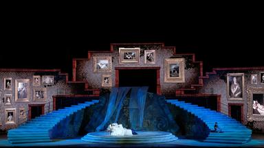 "Aus der Arena di Verona: Giuseppe Verdi - La Traviata": Die Bühne zeigt ein Schlafzimmer mit vielen Bildern an den Wänden.