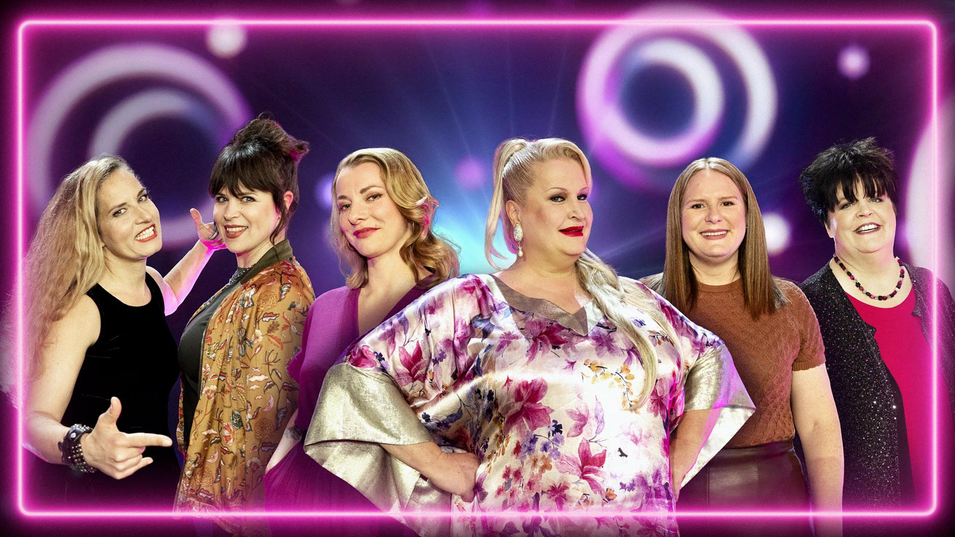 Vier lächelnde Frauen in eleganter Kleidung auf der Bühne.