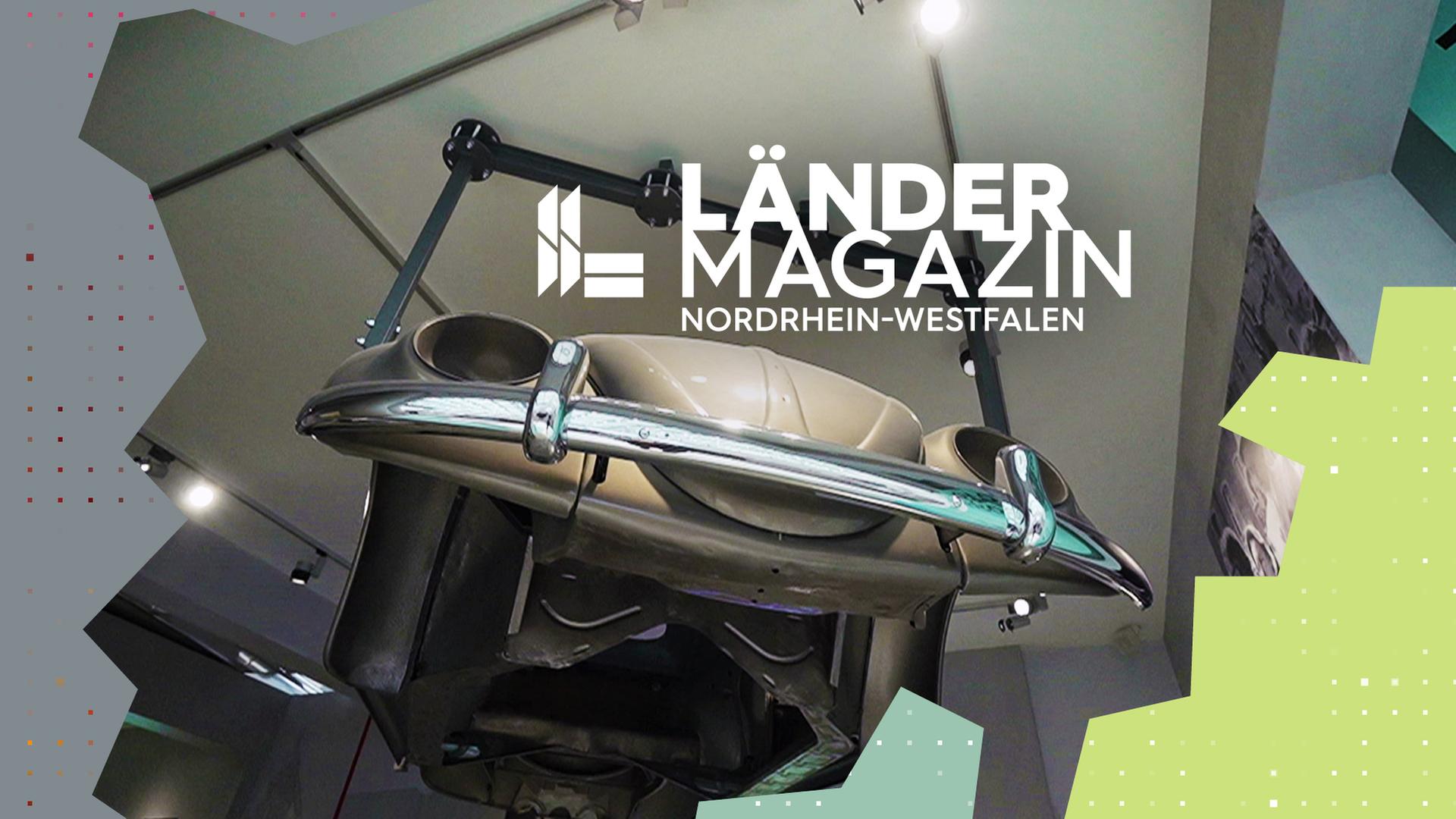 Ein alter heller VW hängt an einer Deckenaufhängung in der Luft