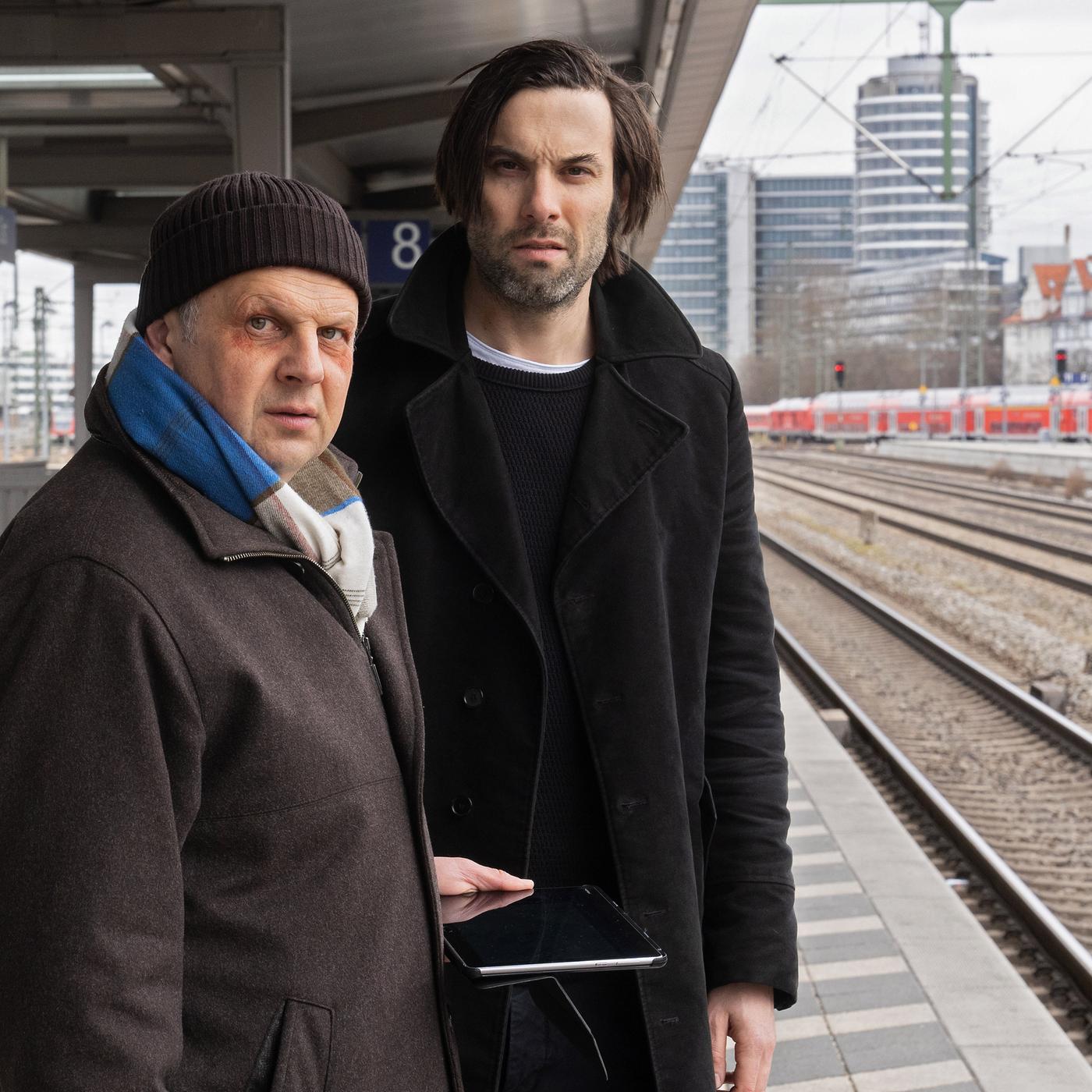 Anton Simhandl (Gerhard Wittmann) und Lukas Laim (Max Simonischek) stehen nebeneinander am Bahnsteig.