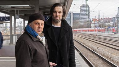 Anton Simhandl (Gerhard Wittmann) und Lukas Laim (Max Simonischek) stehen nebeneinander am Bahnsteig.