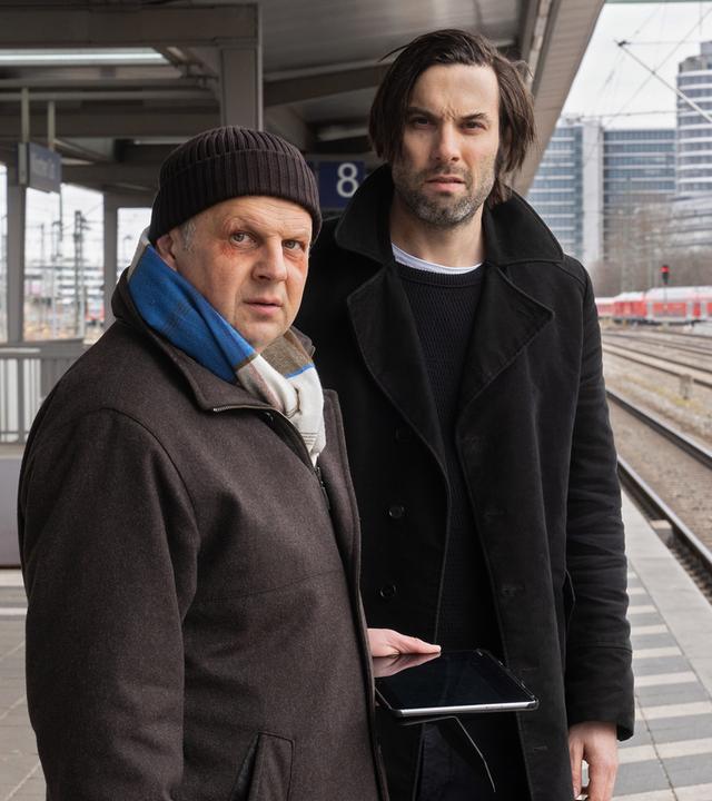 Anton Simhandl (Gerhard Wittmann) und Lukas Laim (Max Simonischek) stehen nebeneinander am Bahnsteig.