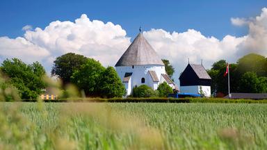 Eine Rundkirche, im Vordergrund eine Wiese