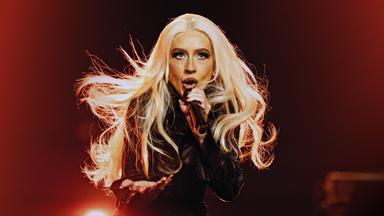 Christina Aguilera singt in ein Mikrofon.