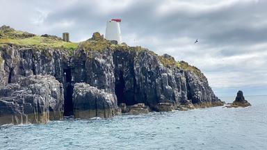 Felsige Insel Isle of May vor der Küste von Anstruther, bedeckt mit Gras und umgeben vom Meer, Lebensraum zahlreicher Seevögel.