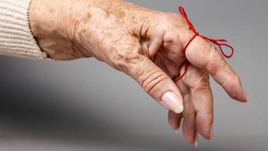 Ausgestreckter Finger mit einer Schleife zur Erinnerung daran. 