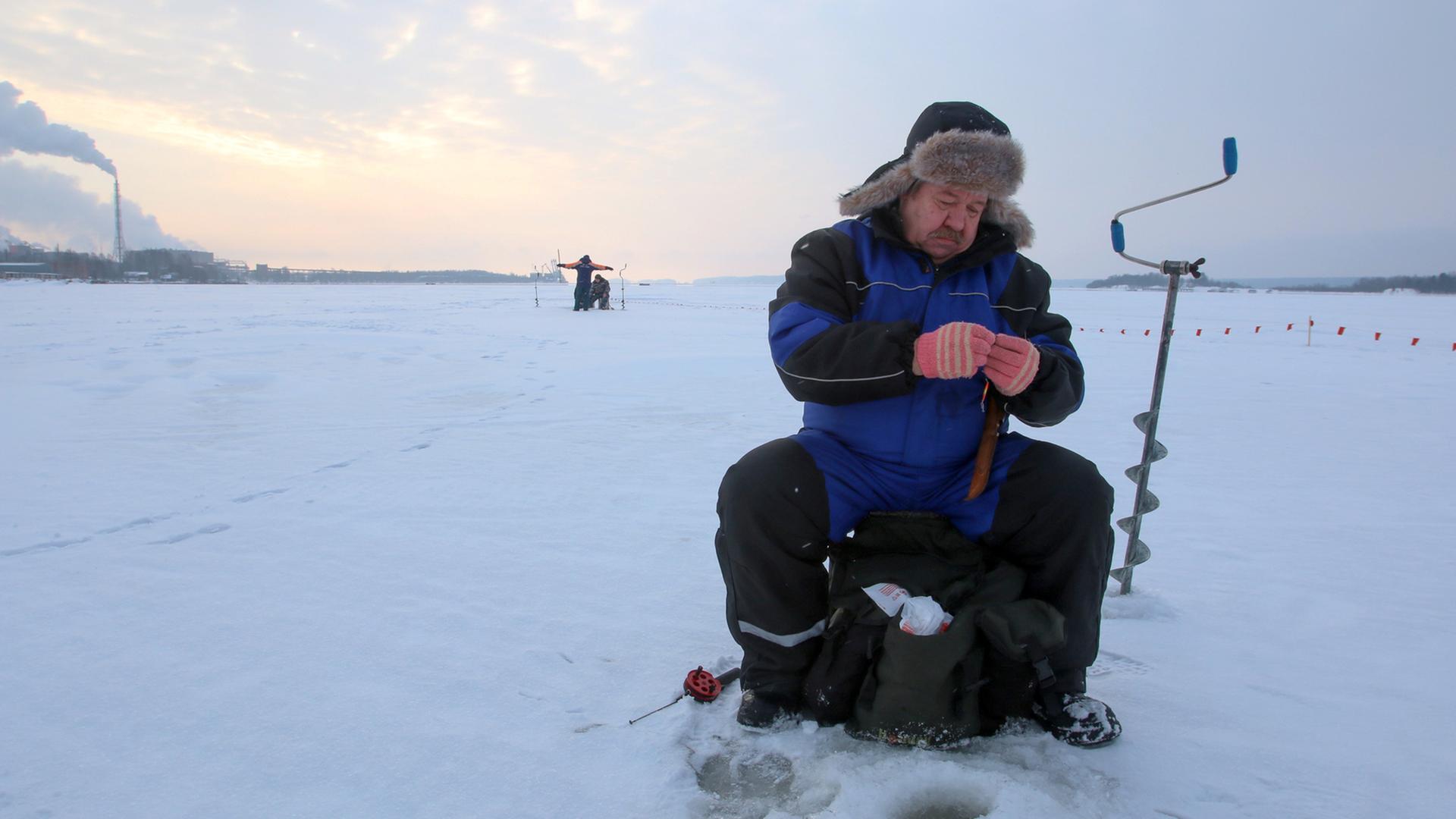 "Let it snow": Ein Mann angelt an einem Eisloch.
