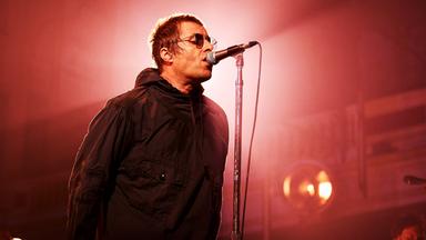 Liam Gallagher singt mit Sonnenbrille ins Mikro.