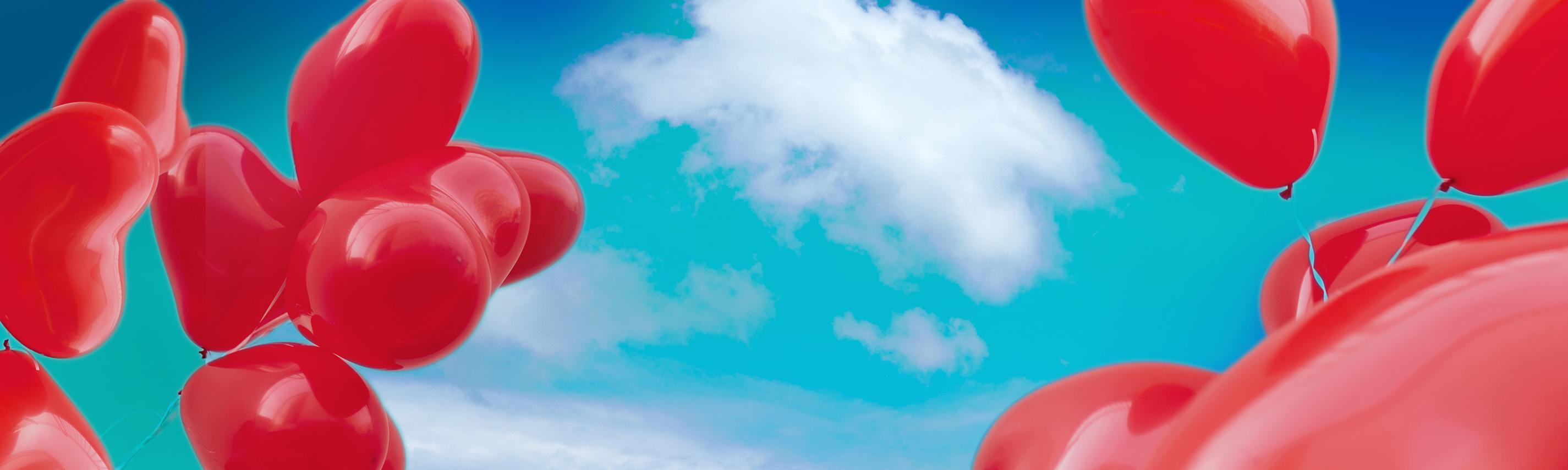  rote Luftballons vor blauem Himmel