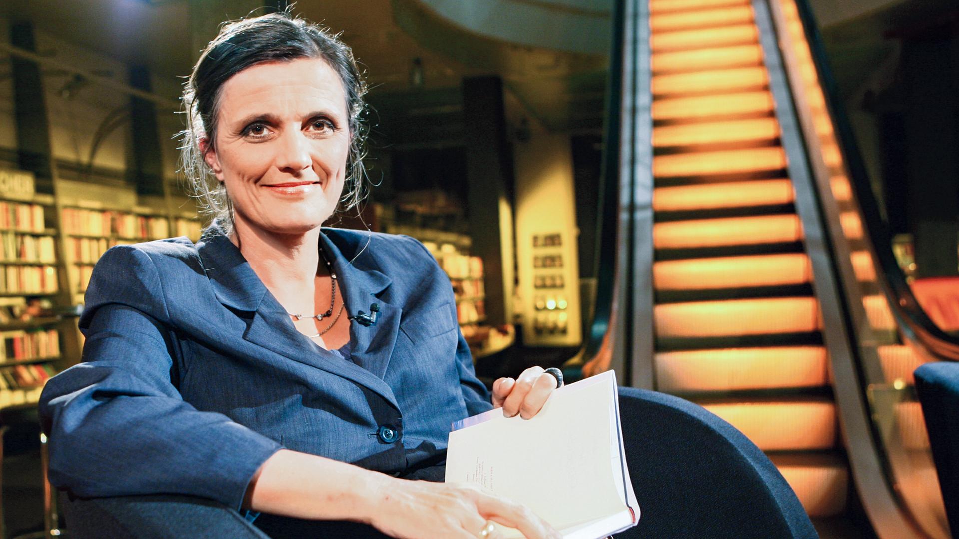 Moderatorin mit Buch im Schoß