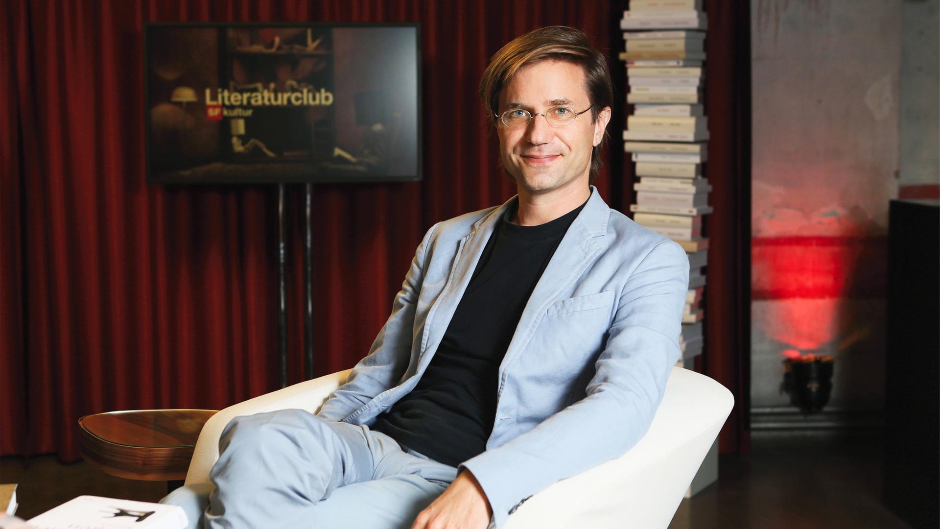 Junger Mann mit Brille im Sessel