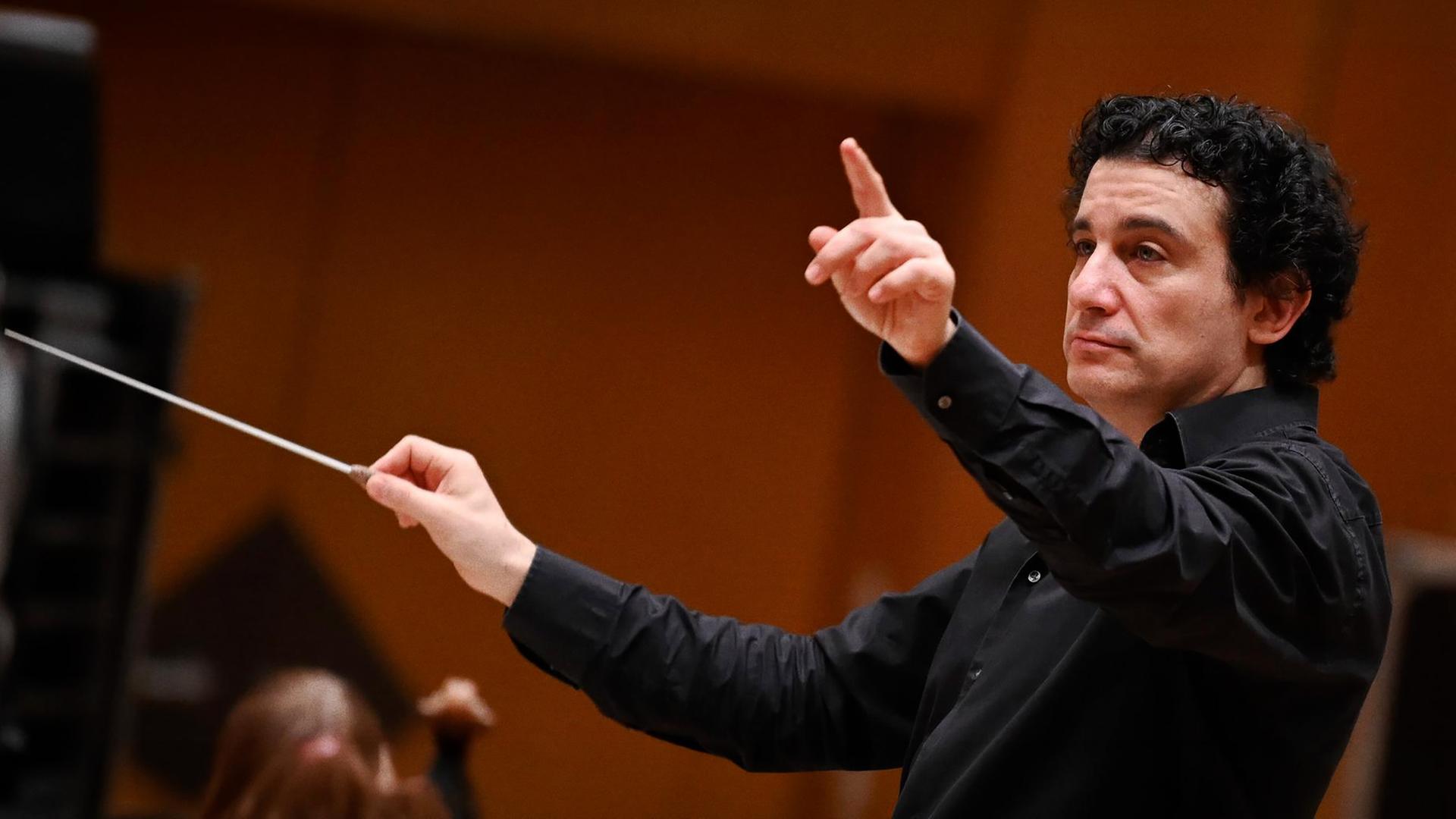 Alain Altinoglu, designierter Chefdirigent des hr-Sinfonieorchesters, mit Dirigentenstab in der rechten Hand und erhobenem linken Zeigefinger.