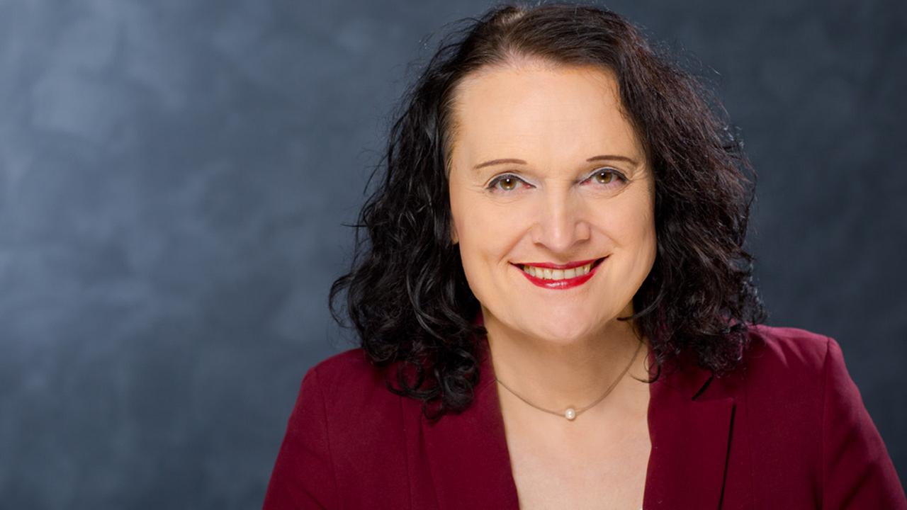 Nahaufnahme von Livia Prüll vor einer grauen Wand.