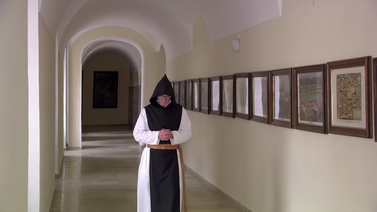 Ein Pater geht durch ein Gewölbe