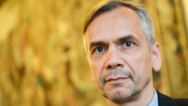 Porträtfoto eines Mannes mit angegrauten Haaren im Anzug.