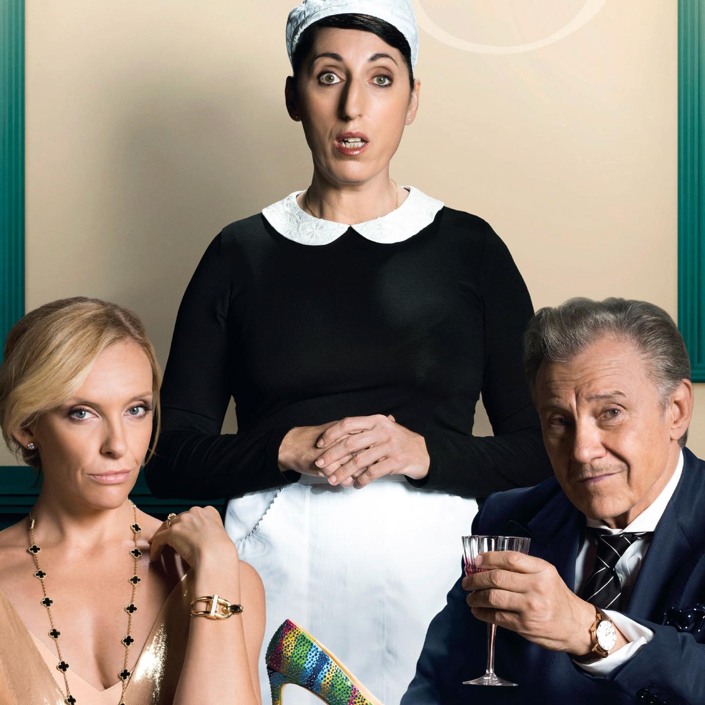 Anne (Toni Collette) und Bob (Harvey Keitel) sitzen in festlicher Kleidung an einem Tisch mit weiteren Gästen. Hinter ihnen beiden steht Maria (Rossy de Palma) in Dienstmädchenuniform. Alle drei schauen frontal in Richtung des Betrachters, Bob erhebt prostend ein Weinglas.