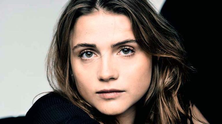 Eine junge Frau mit braunem Haar und einem schwarzen Shirt.