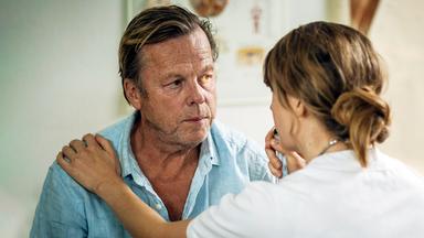 Ein Mann wird von einer jungen Ärztin untersucht.