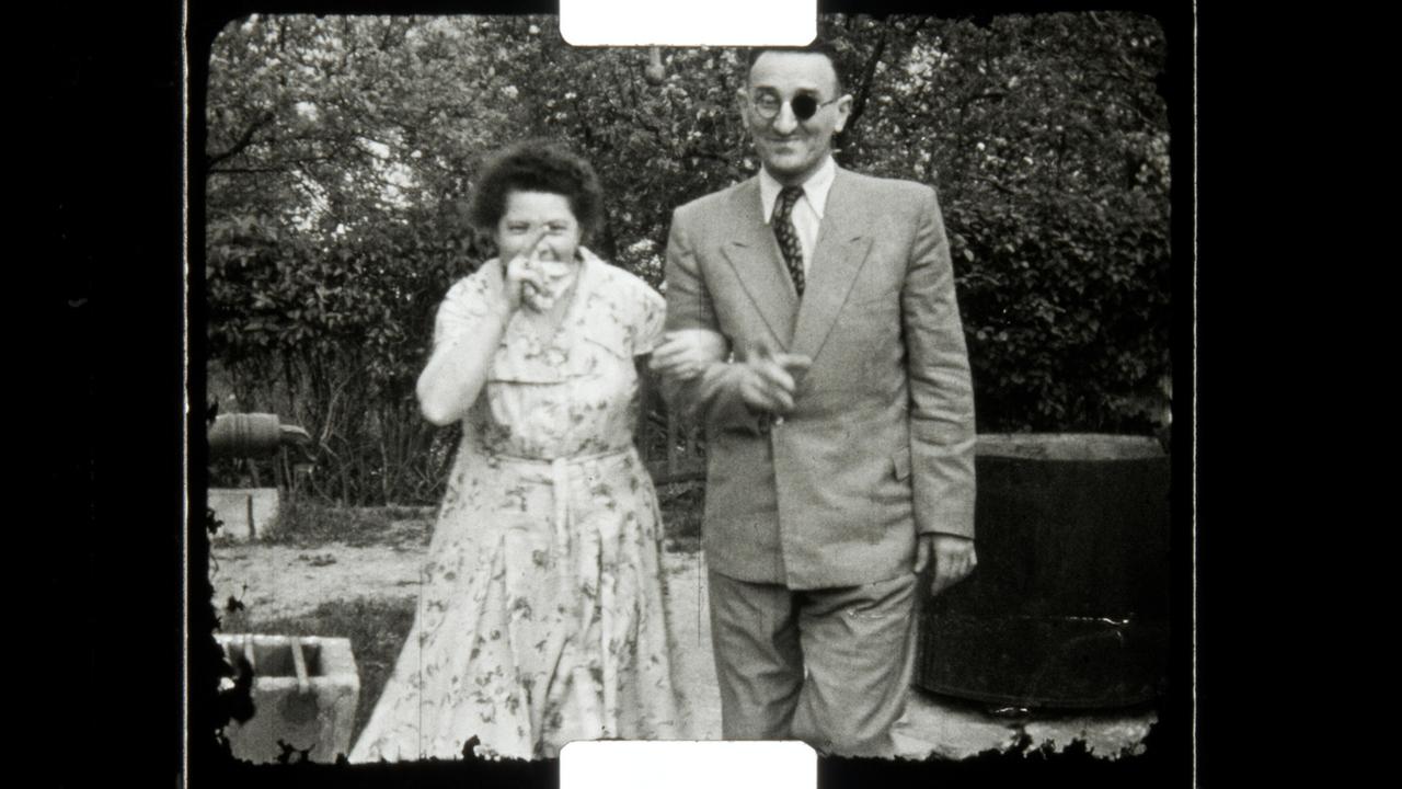 Ein Mann im hellen Anzug steht neben einer Frau im Sommerkleid