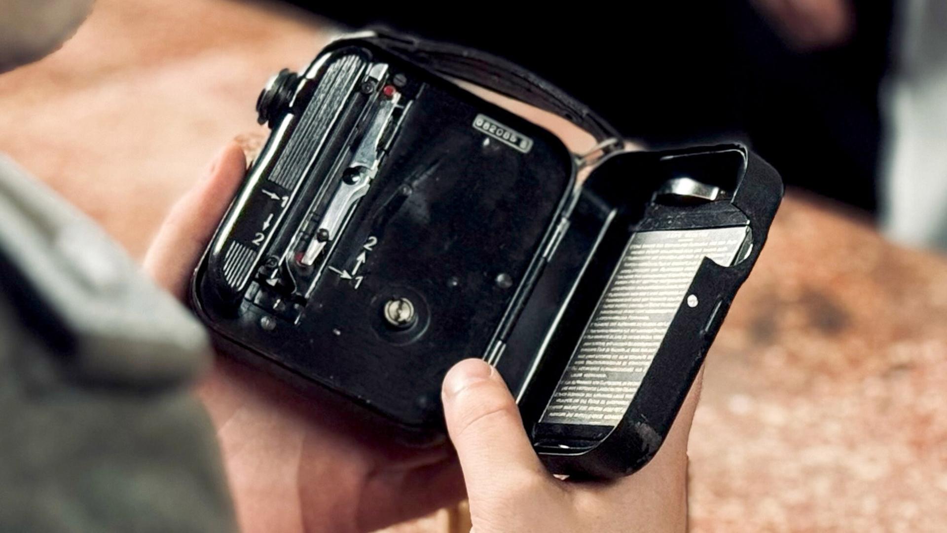 In eine kleine handliche alte Filmkamera wird ein Film eingelegt