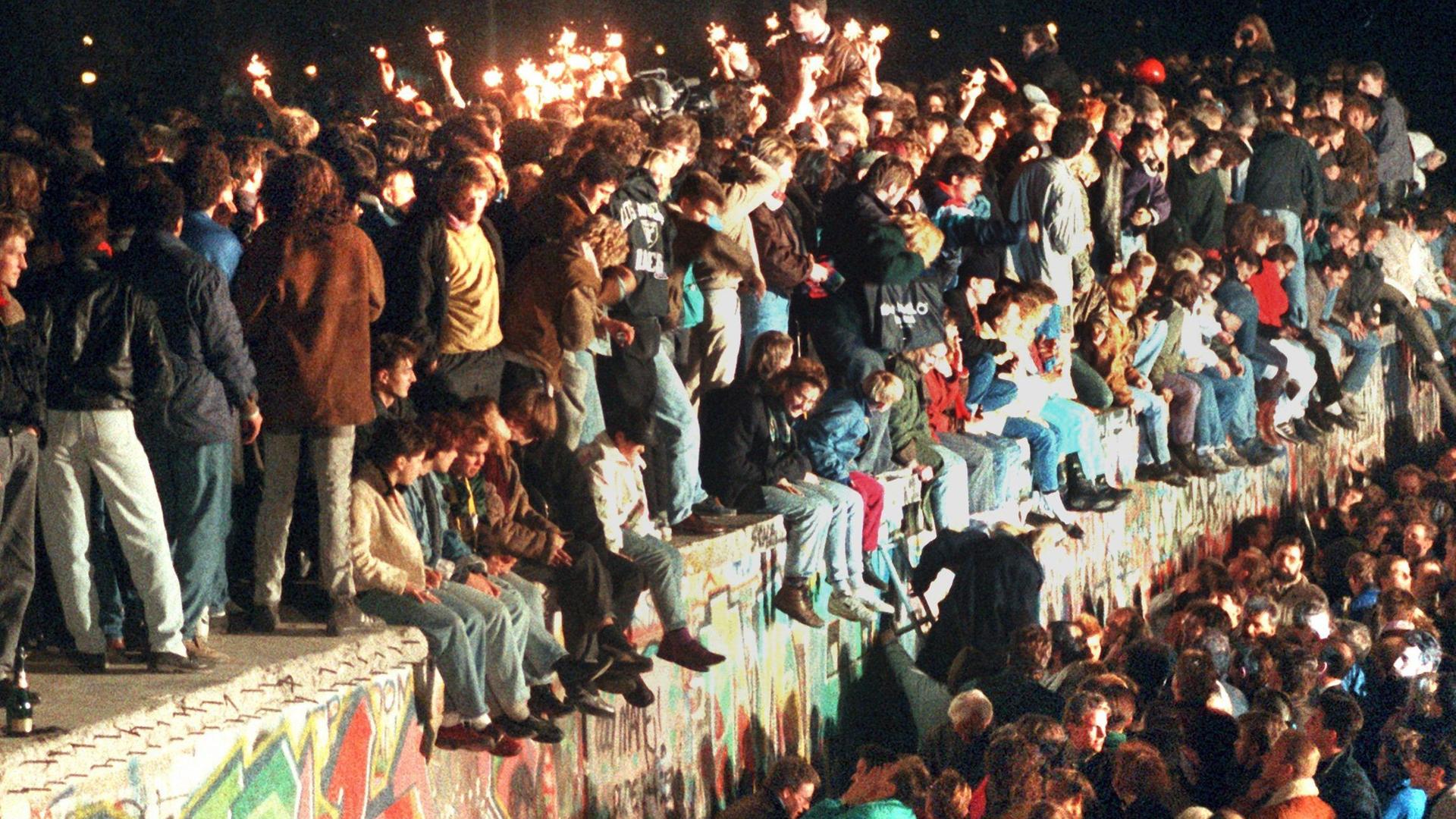 Menschen auf derr Berliner Mauer