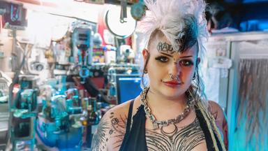 "Megacitys – Wenn es Nacht wird in London": Eine tätowierte Punk-Frau mit weißen hochstehenden Haaren und Piercings im Gesicht schaut in die Kamera.