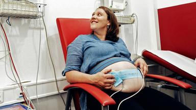 Eine Frau auf einem Stuhl in einem Behandlungszimmer.