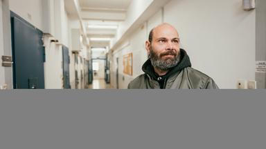 Thorsten steht im Gefängnisflur.