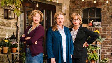 Drei Frauen vor einem Hofeingang. Die beiden äußeren Frauen ähneln sich sehr.