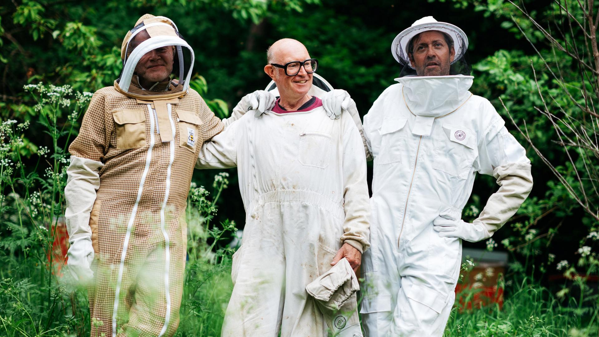 Drei Männer im hellen Imkeroutfit