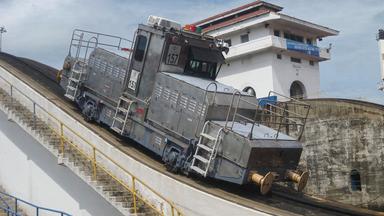 Eine Lokomotive fährt eine Anhöhe hoch.