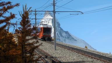 Eine Bahn auf Gleisen. Im Hintergrund das Matterhorn.