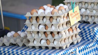 Gestapelte Eierkartons auf einem Markstand.