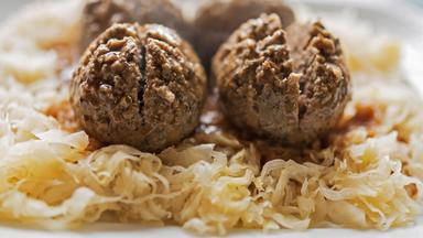Eine Pfälzer Spezialität, Leberknödel mit Sauerkraut, fertig gekocht, zum Verzehr bereit, auf einem Teller serviert.