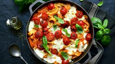 Überbackene Nudeln in einer gusseisernen Pfanne, fotografiert von oben.