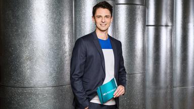 Moderator Peter Schneeberger steht vor Wand