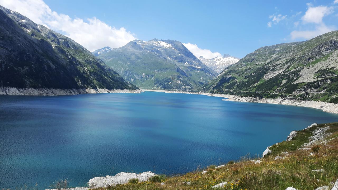 Das Bild zeigt einen Bergsee und ein Bergpanorama im Hintergrund
