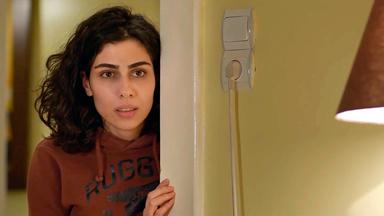 Schauspielerin Heja Türk schaut verängstigt hinter einer Tür hervor