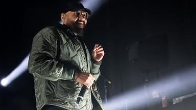 Ein schwarzer Musiker singt auf der Bühne.