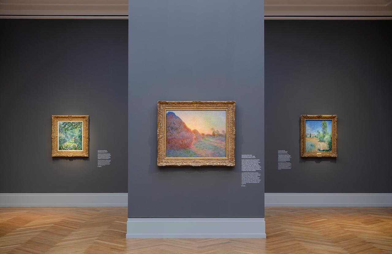 Drei Bilder des Künstlers Claude Monet in einem Museumsraum.
