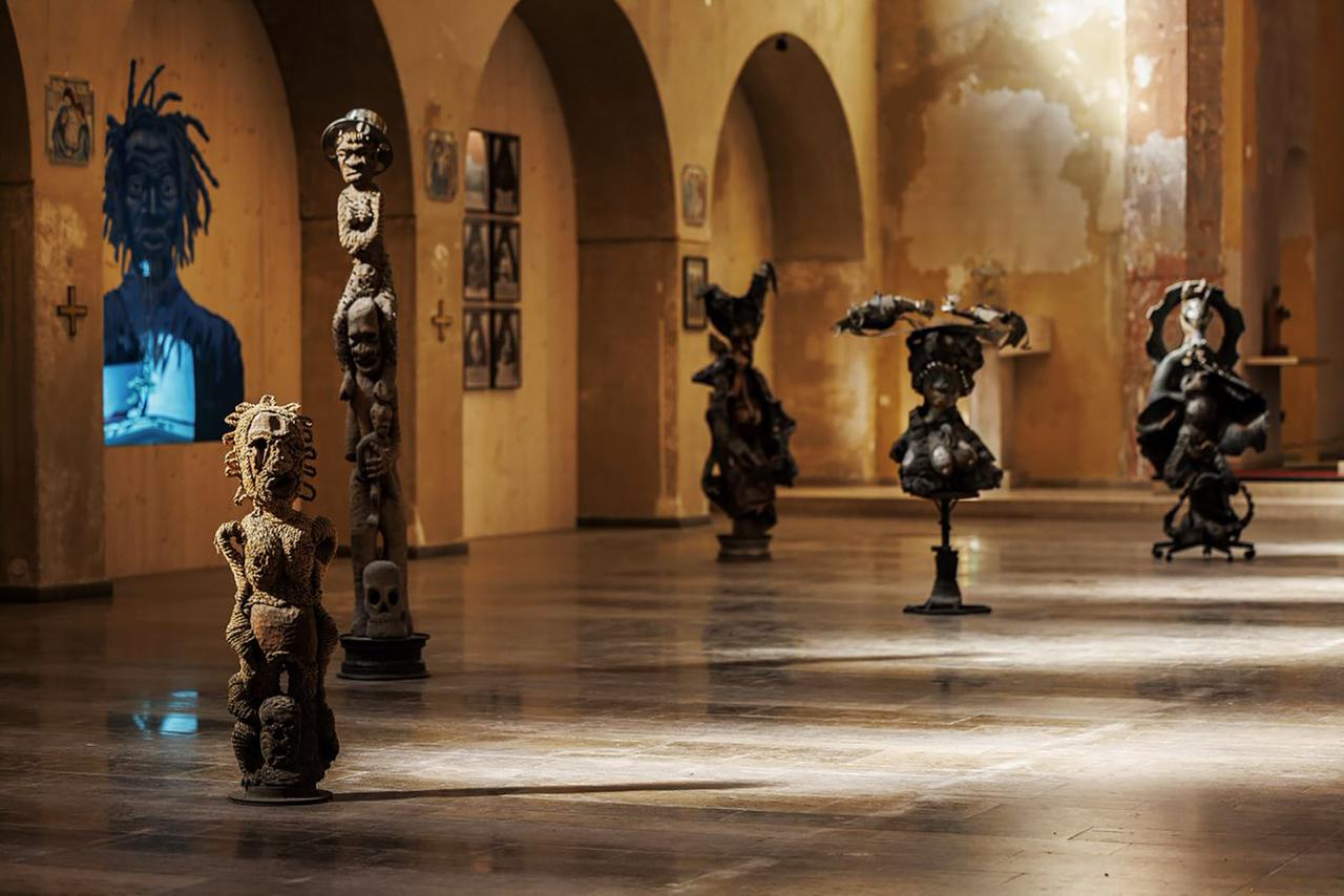 Mehrere braune menschliche Figuren und Köpfe in einem Ausstellungsraum